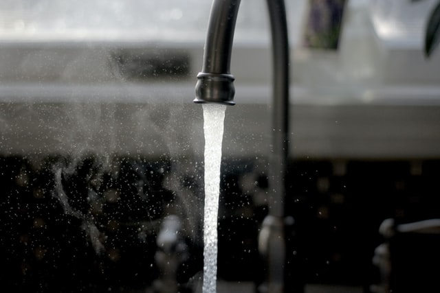 Spolar varmt vatten ur kranen för att få bort stopp i avlopp Stockholm